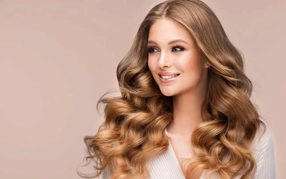 toothy smile face lovely model with long lush wavy deep blonde hairstyle hairdressing art